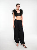 Black balloon trousers by MOSAÏKA styled with feather top on model